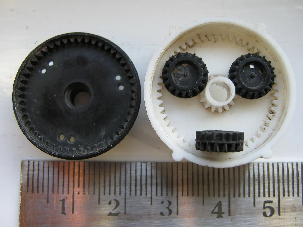 Plastic gears laid out beside a ruler